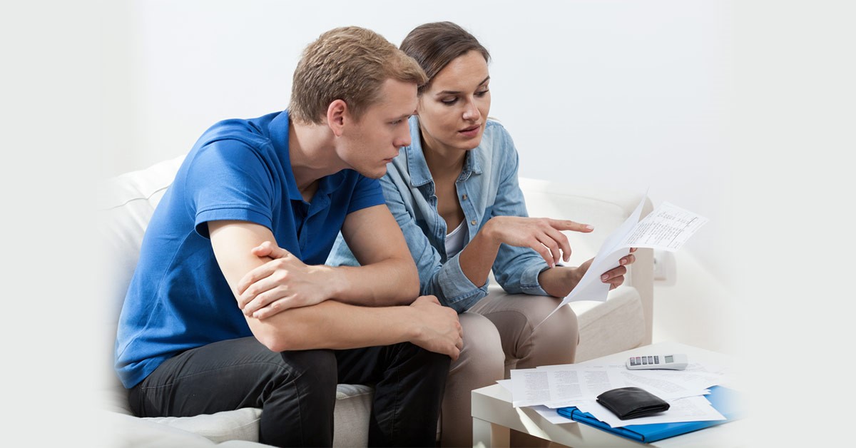Couple sitting on couch looking at documents together